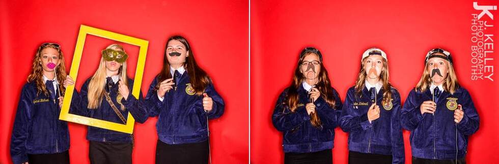 Three high school girls, props on a stick, red backdrop, Columbia MO 